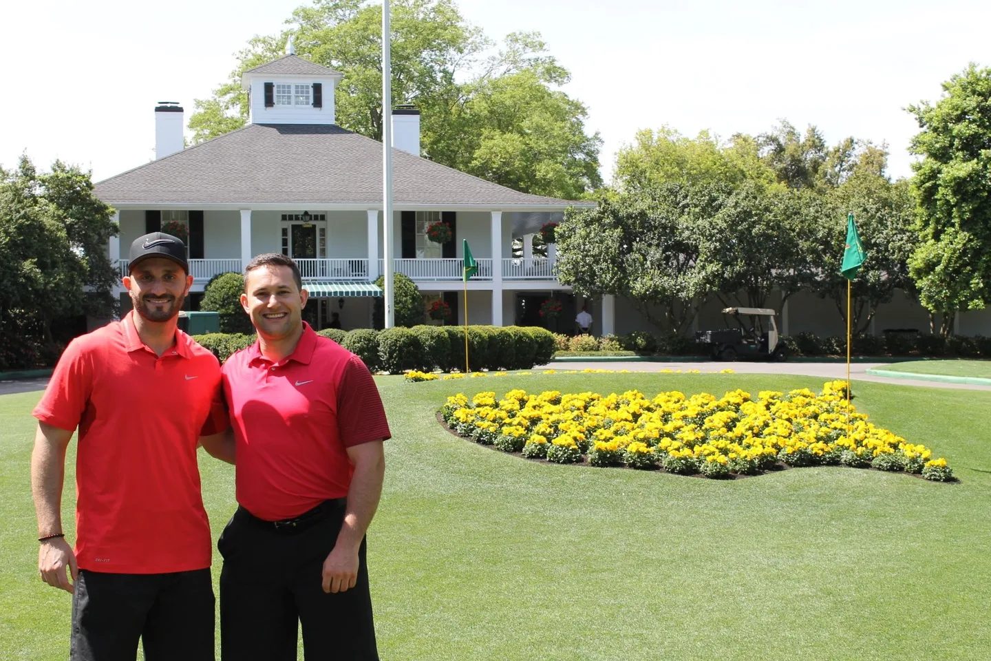 Jordan Simon and a friend in golf shirts in front of the Augusta National clubhouse