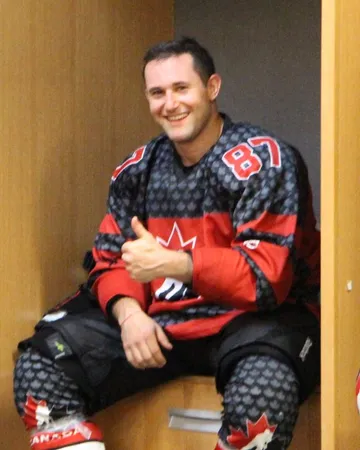 Jordan Simon in a hockey jersey, smiling in the locker room